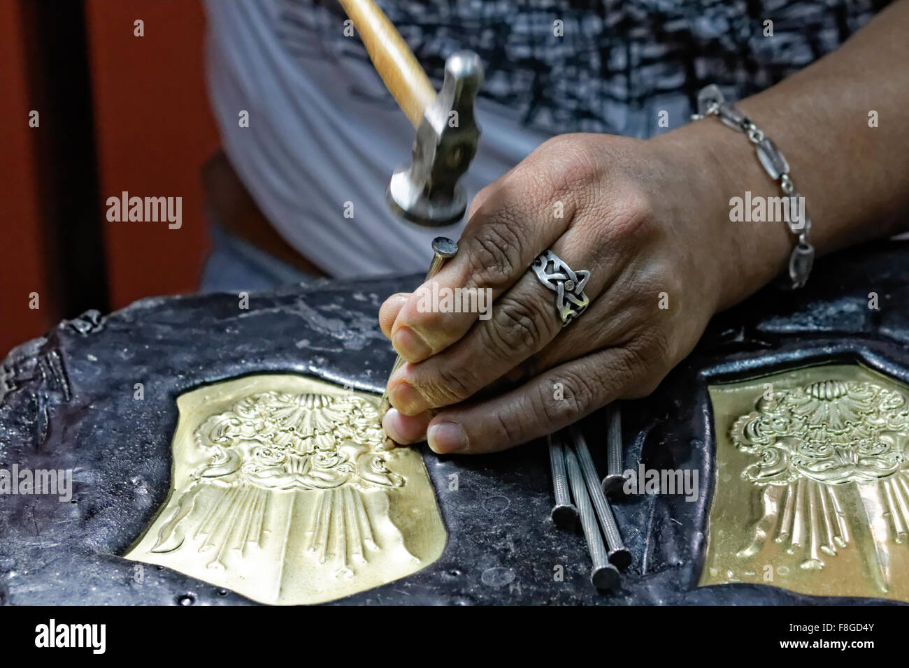 A craftsman working on a metal engraving in Calle La Ronda in Old Town Quito, Ecuador. Stock Photo