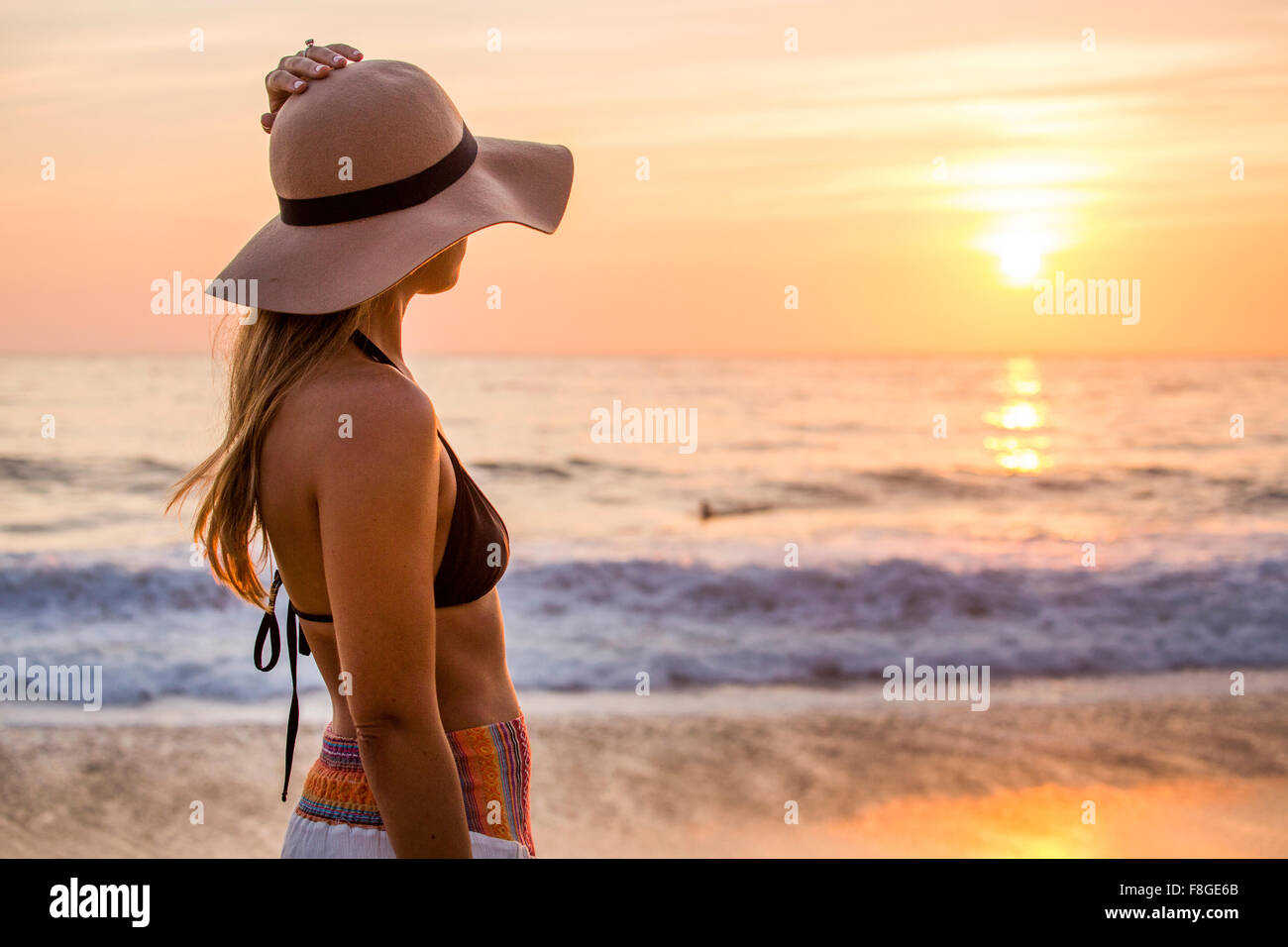 Caucasian woman admiring sunset and ocean Stock Photo