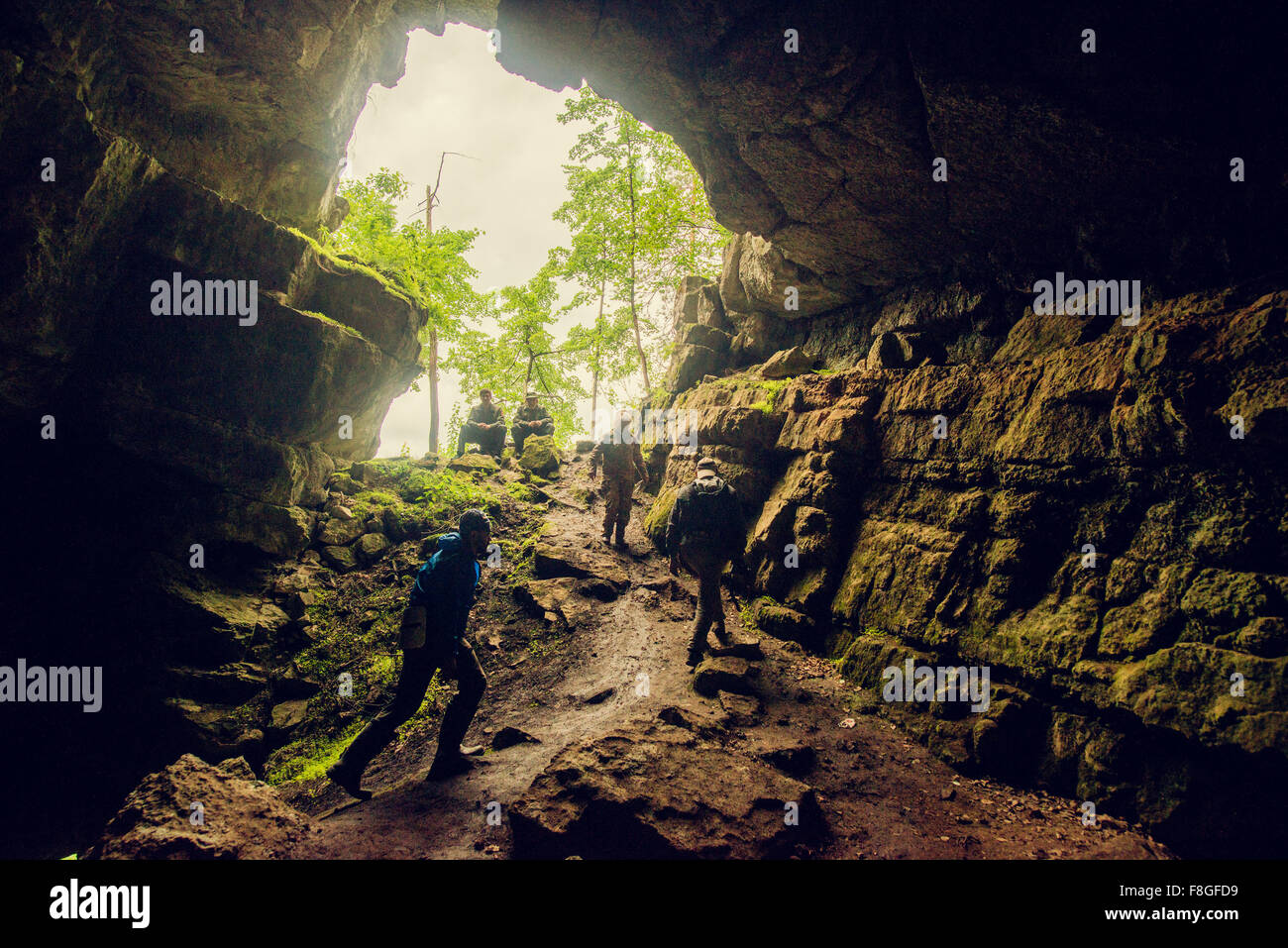 Hikers exploring rock cave Stock Photo