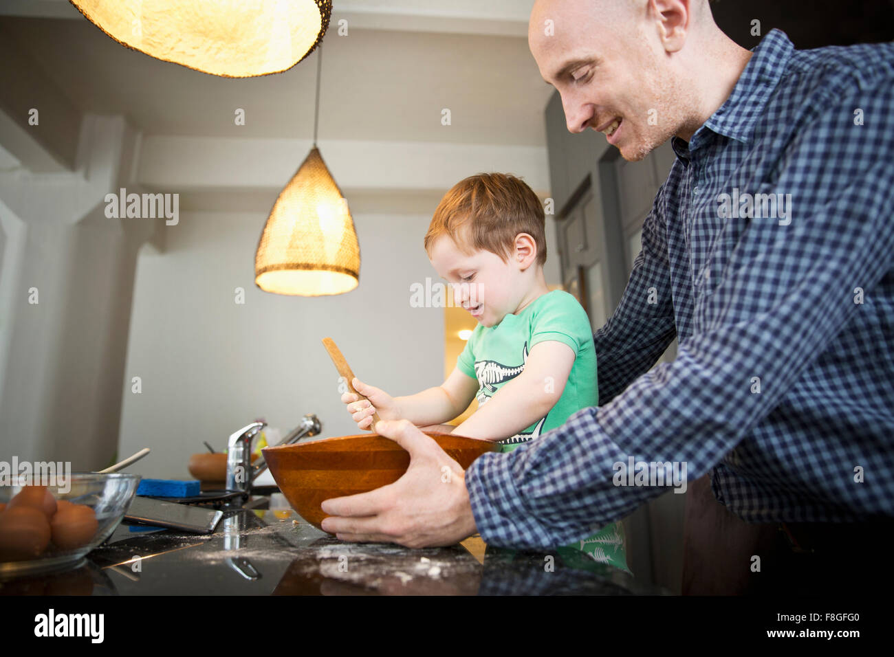 Father teaching son to cook in kitchen Stock Photo