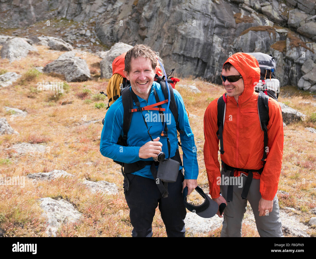 Caucasian hikers smiling on hillside Stock Photo