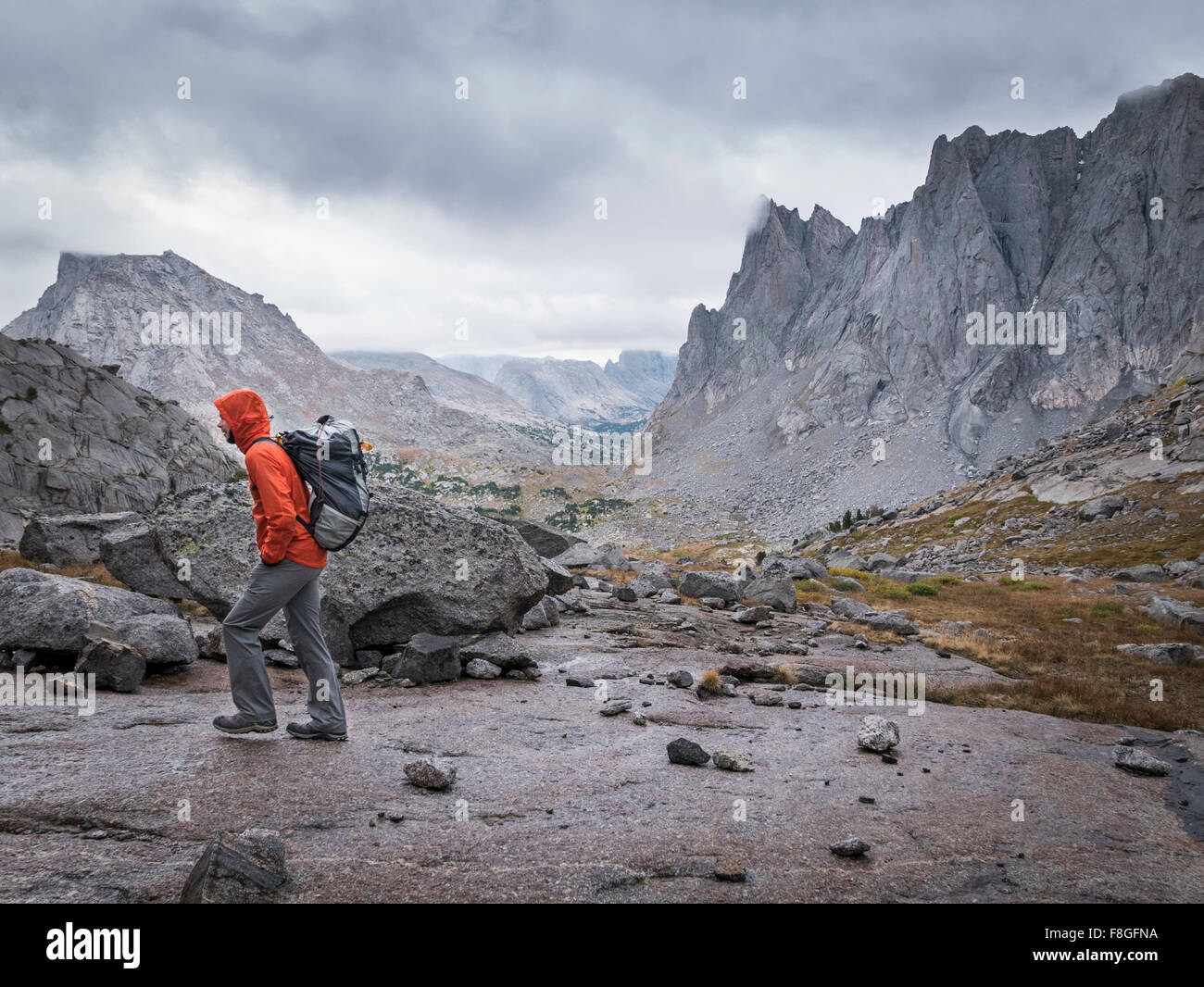 Caucasian hiker walking near mountains Stock Photo