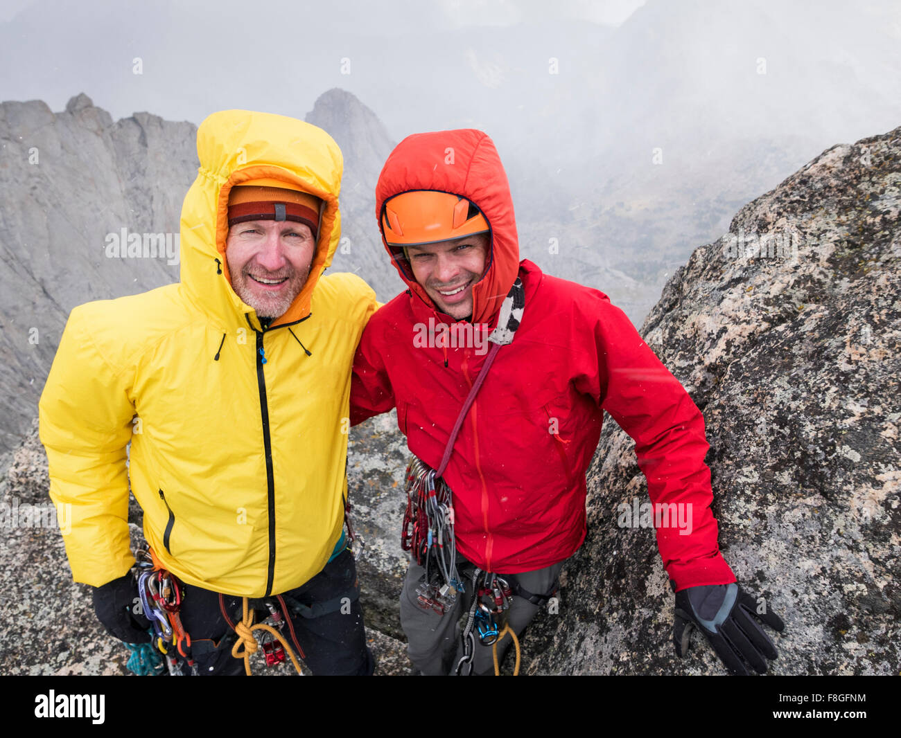 Caucasian climbers smiling on hillside Stock Photo