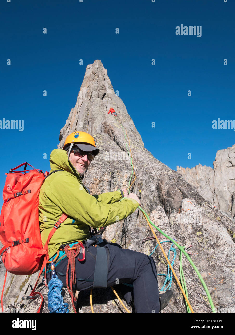 Caucasian climber smiling on mountainside Stock Photo