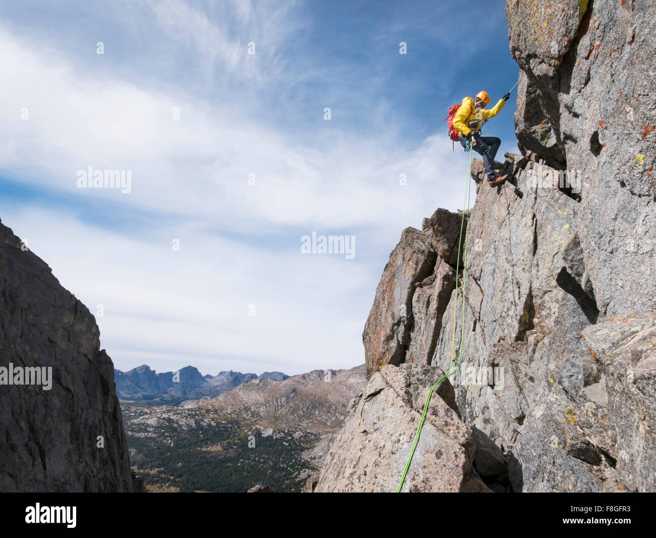Caucasian climber rappelling on mountainside Stock Photo