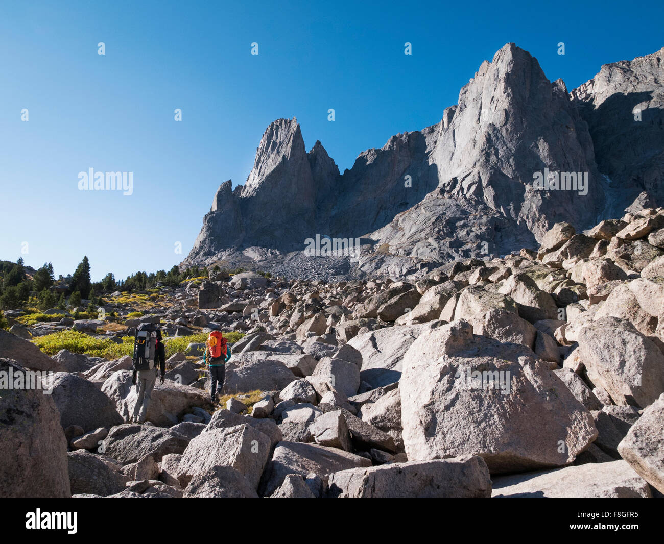 Caucasian hikers walking in rocky field Stock Photo
