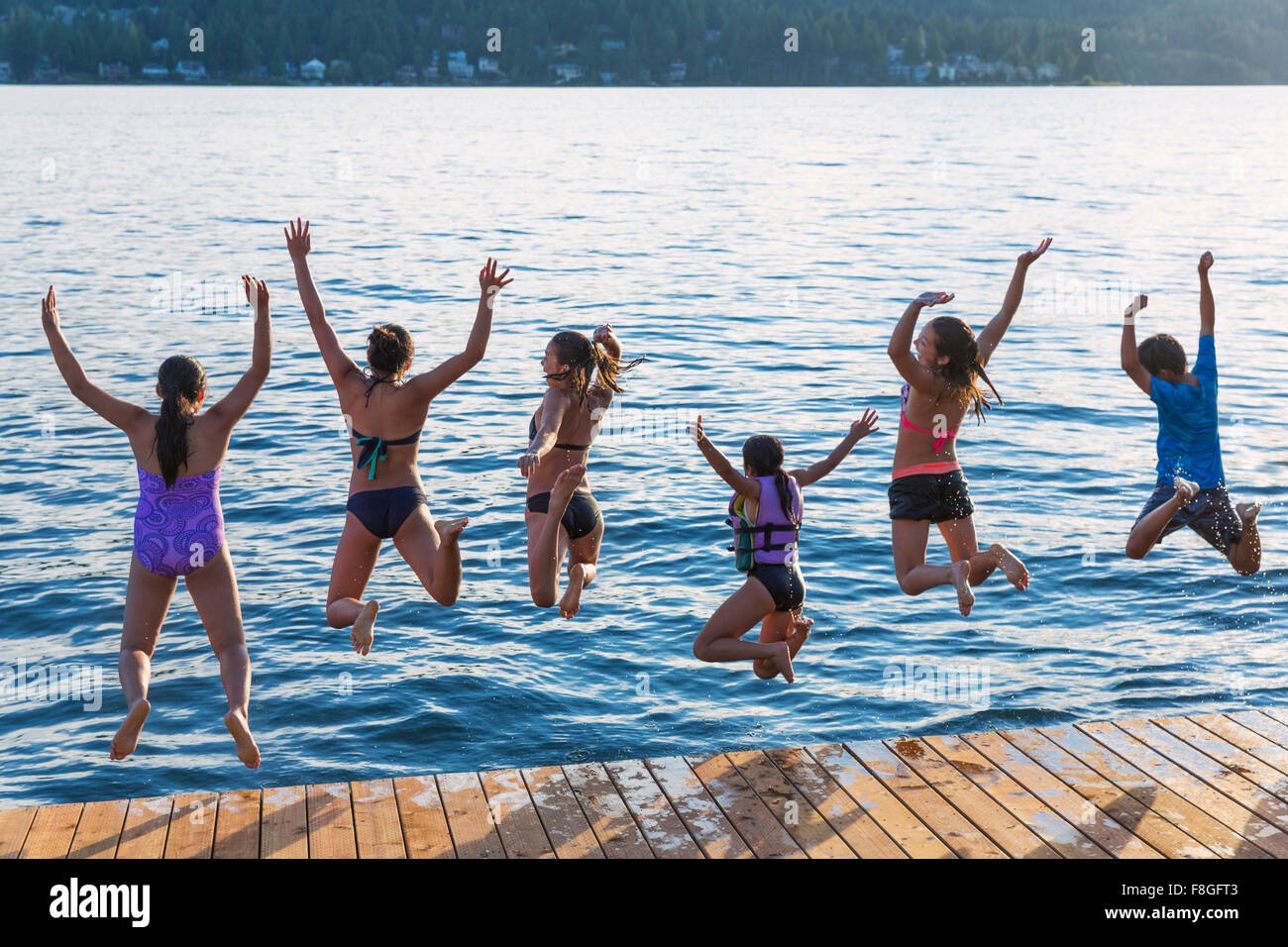 Children jumping into lake Stock Photo