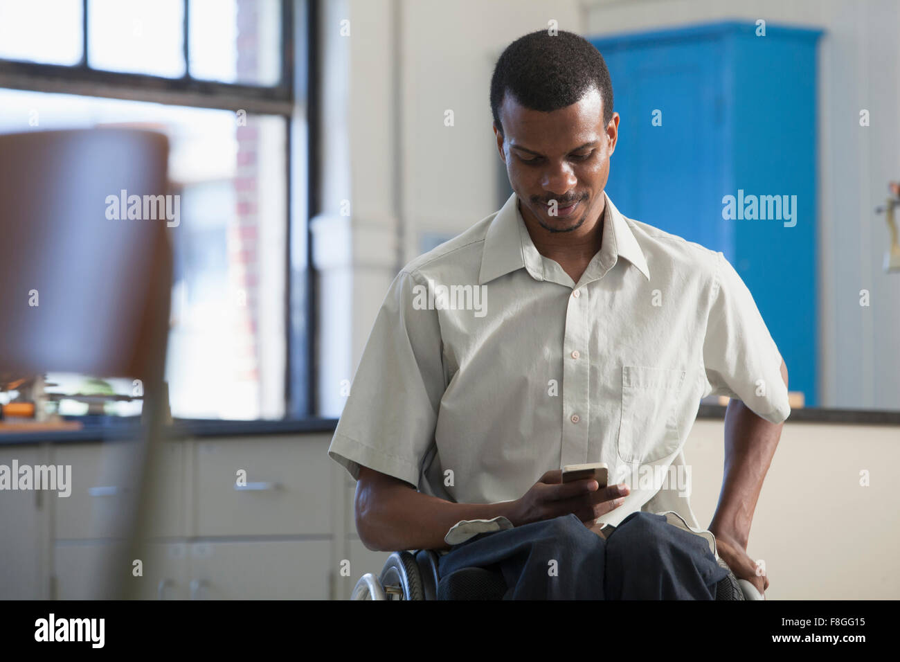 African American paraplegic man using cell phone Stock Photo