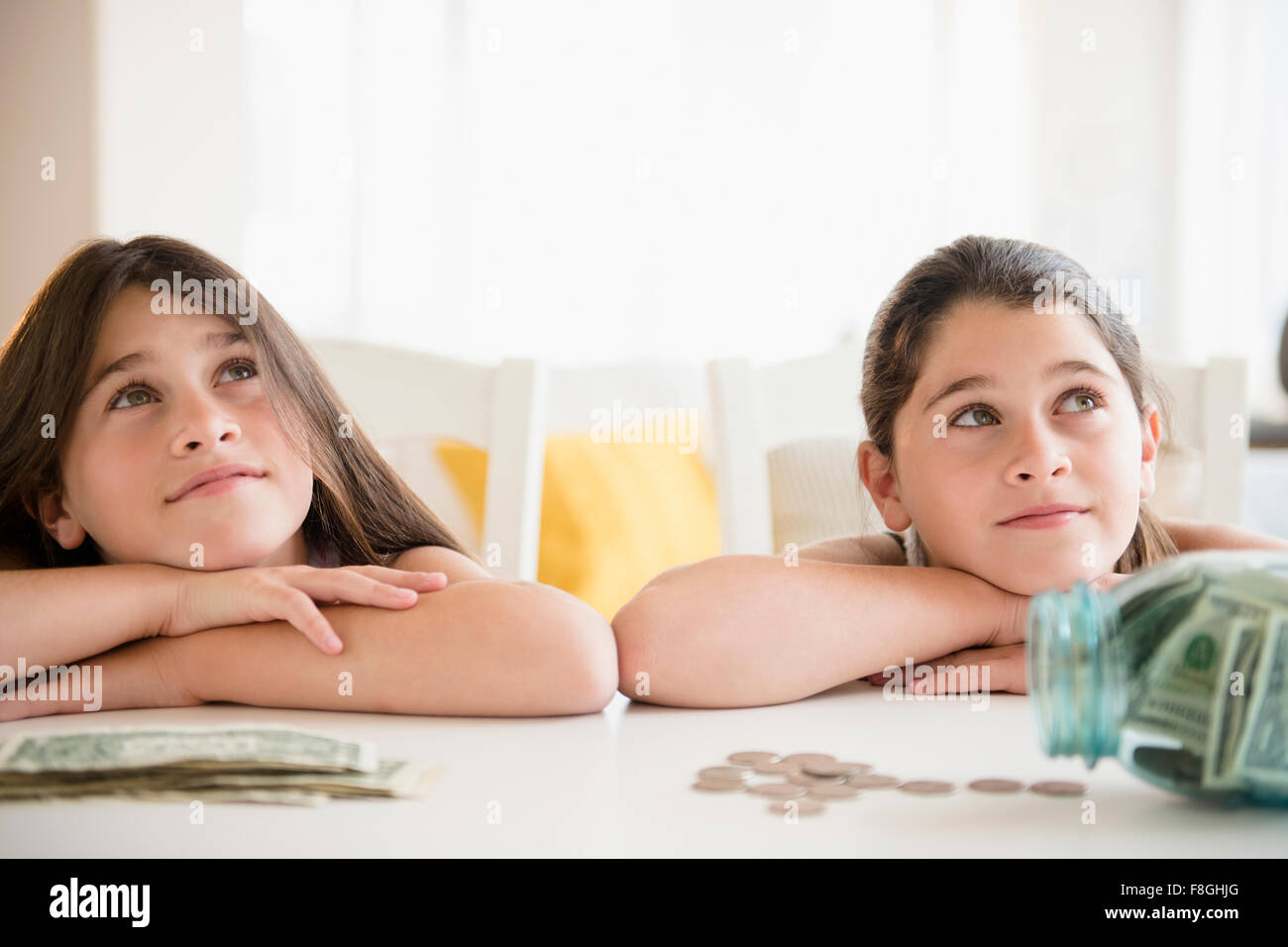 Caucasian twin sisters daydreaming Stock Photo