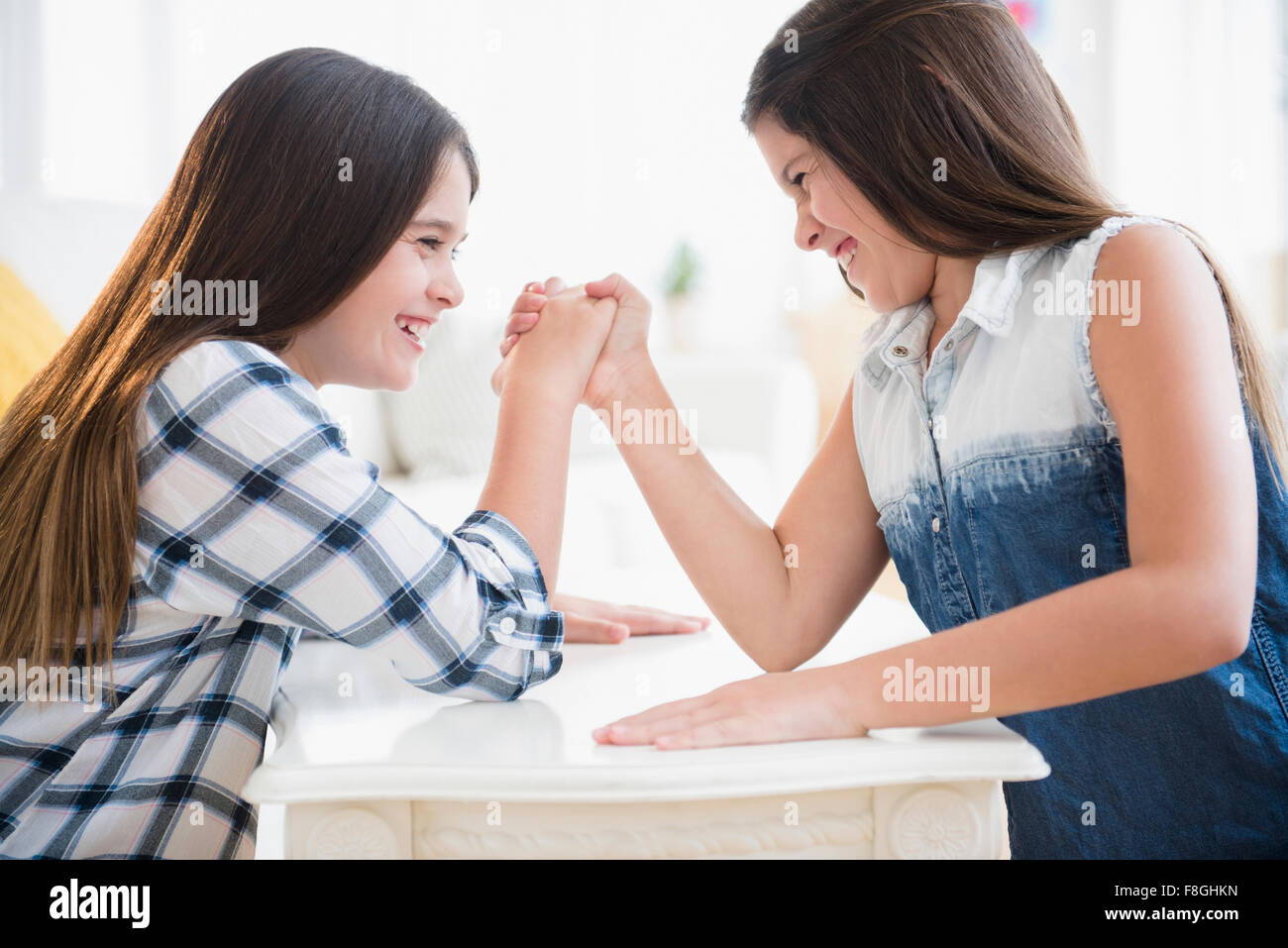 Caucasian twin sisters arm wrestling Stock Photo