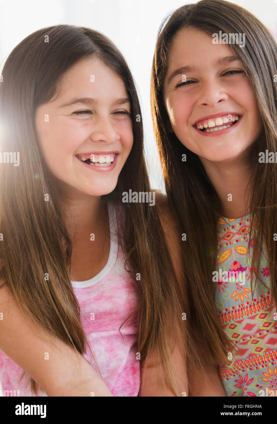 Caucasian twin sisters smiling Stock Photo