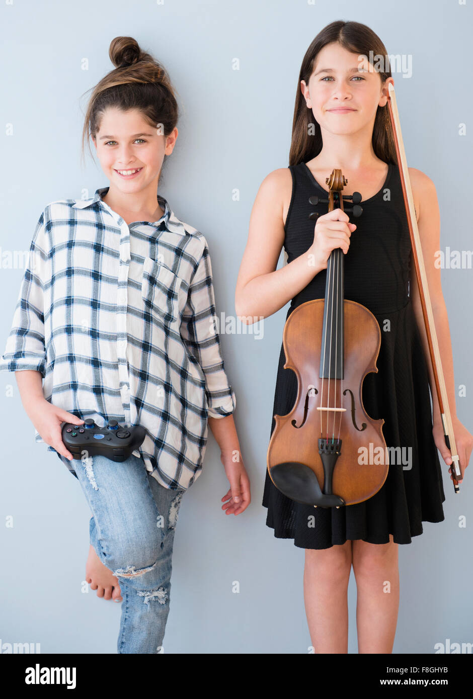 Caucasian twin sisters with opposite hobbies Stock Photo