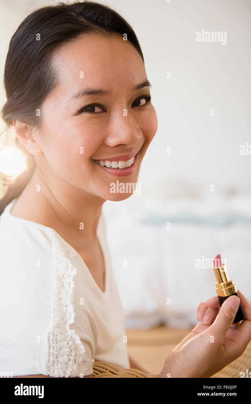 Chinese woman applying lipstick Stock Photo