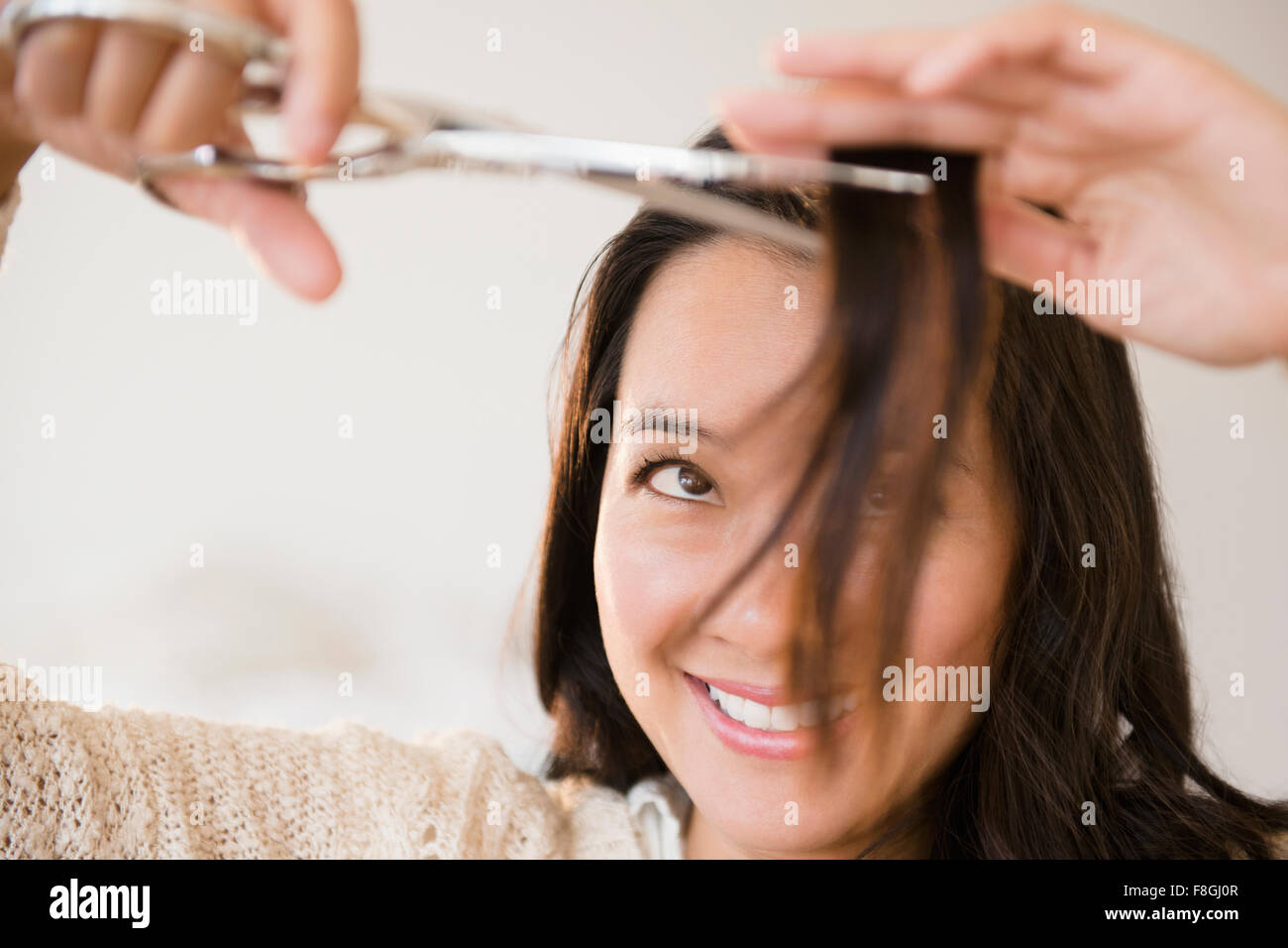 Chinese woman cutting her bangs Stock Photo