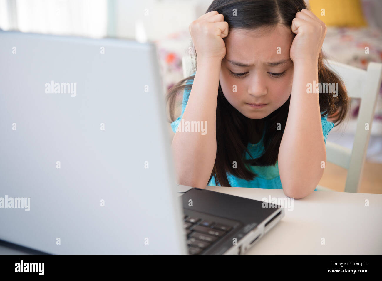 Frustrated girl using laptop Stock Photo