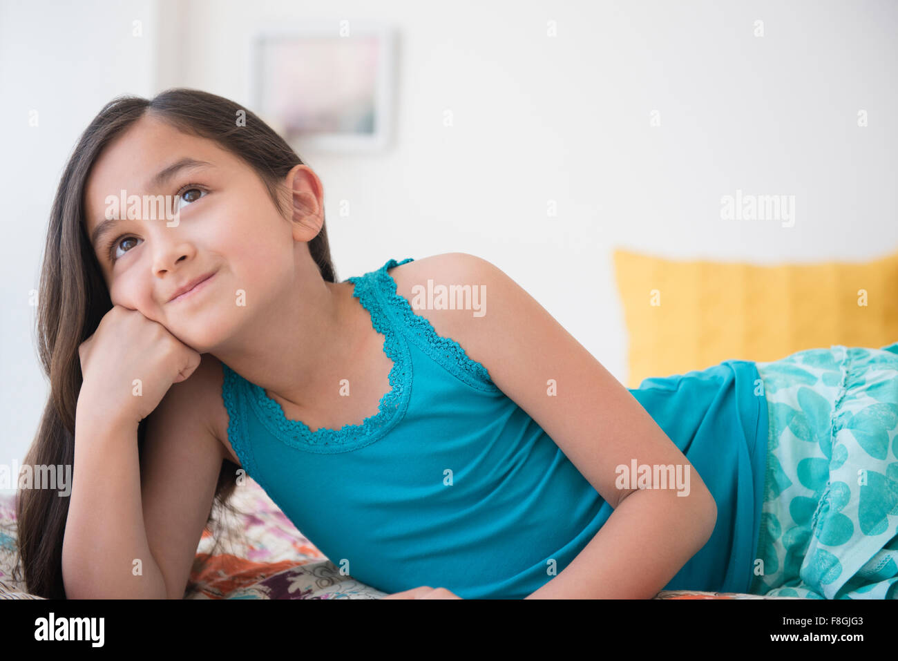 Smiling girl daydreaming with chin in hand Stock Photo