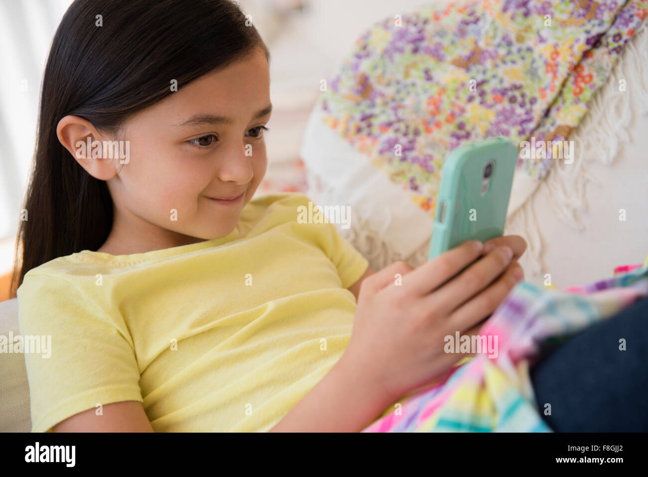 Smiling girl using cell phone Stock Photo