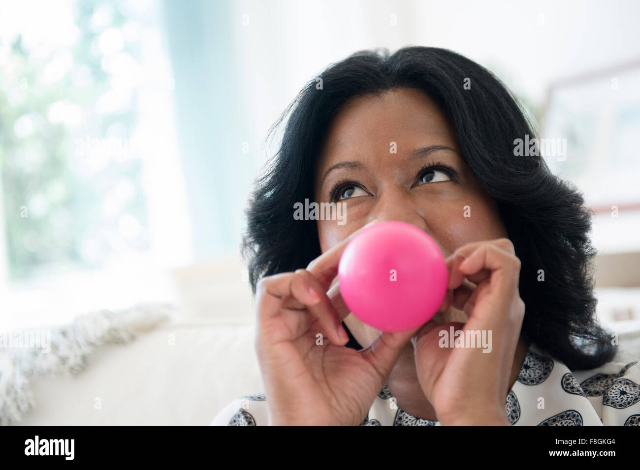 Black woman inflating balloon Stock Photo