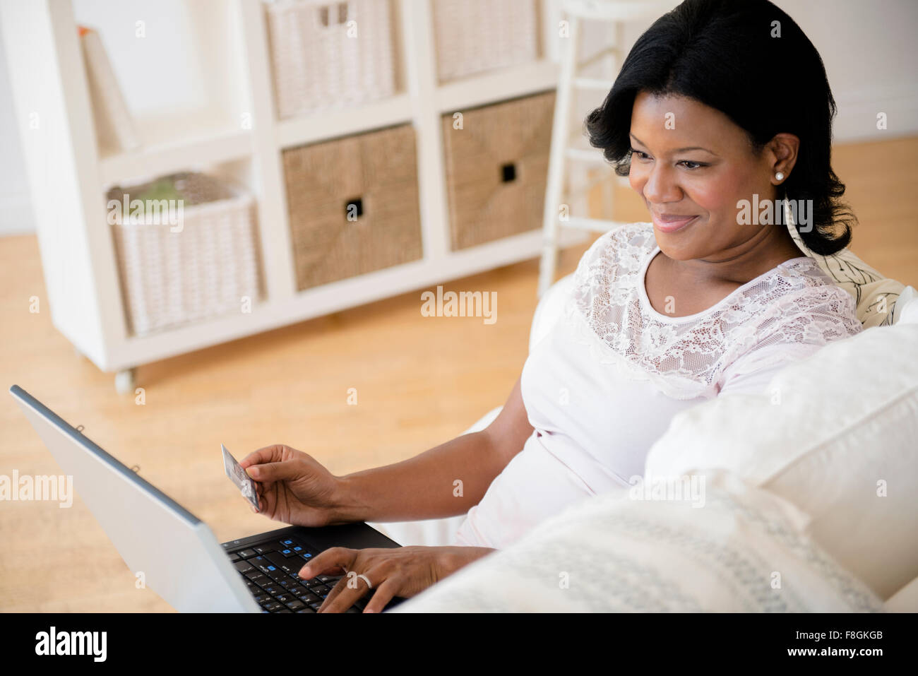 Black woman paying bills on laptop Stock Photo
