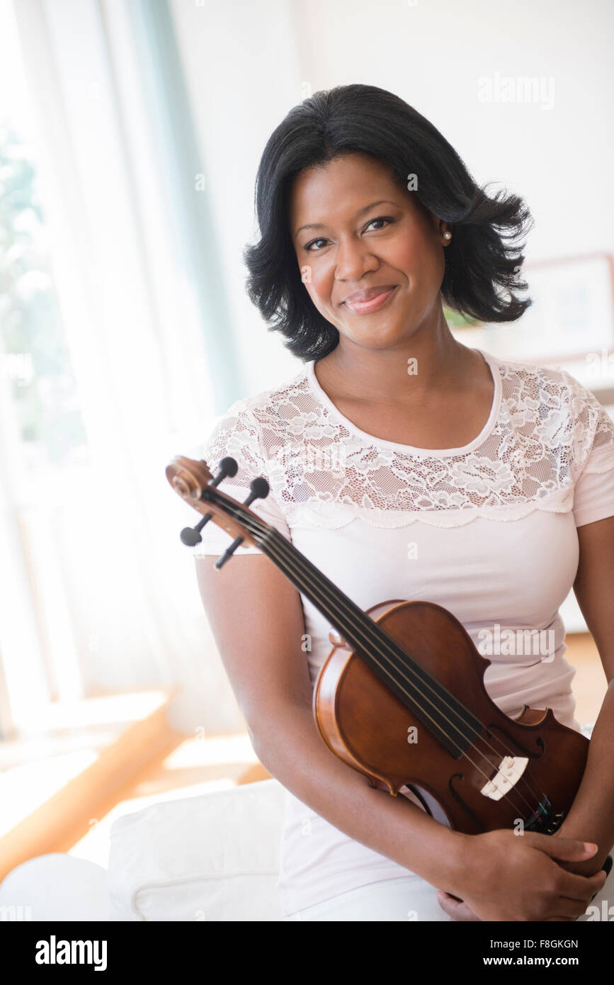 Black woman holding violin Stock Photo