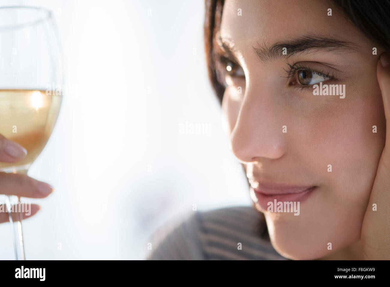 Hispanic woman examining glass of wine Stock Photo