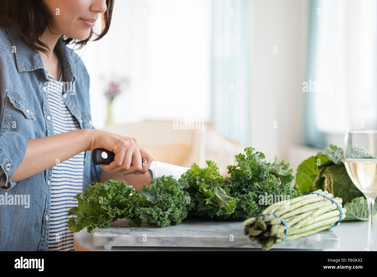 Hispanic woman chopping salad greens Stock Photo