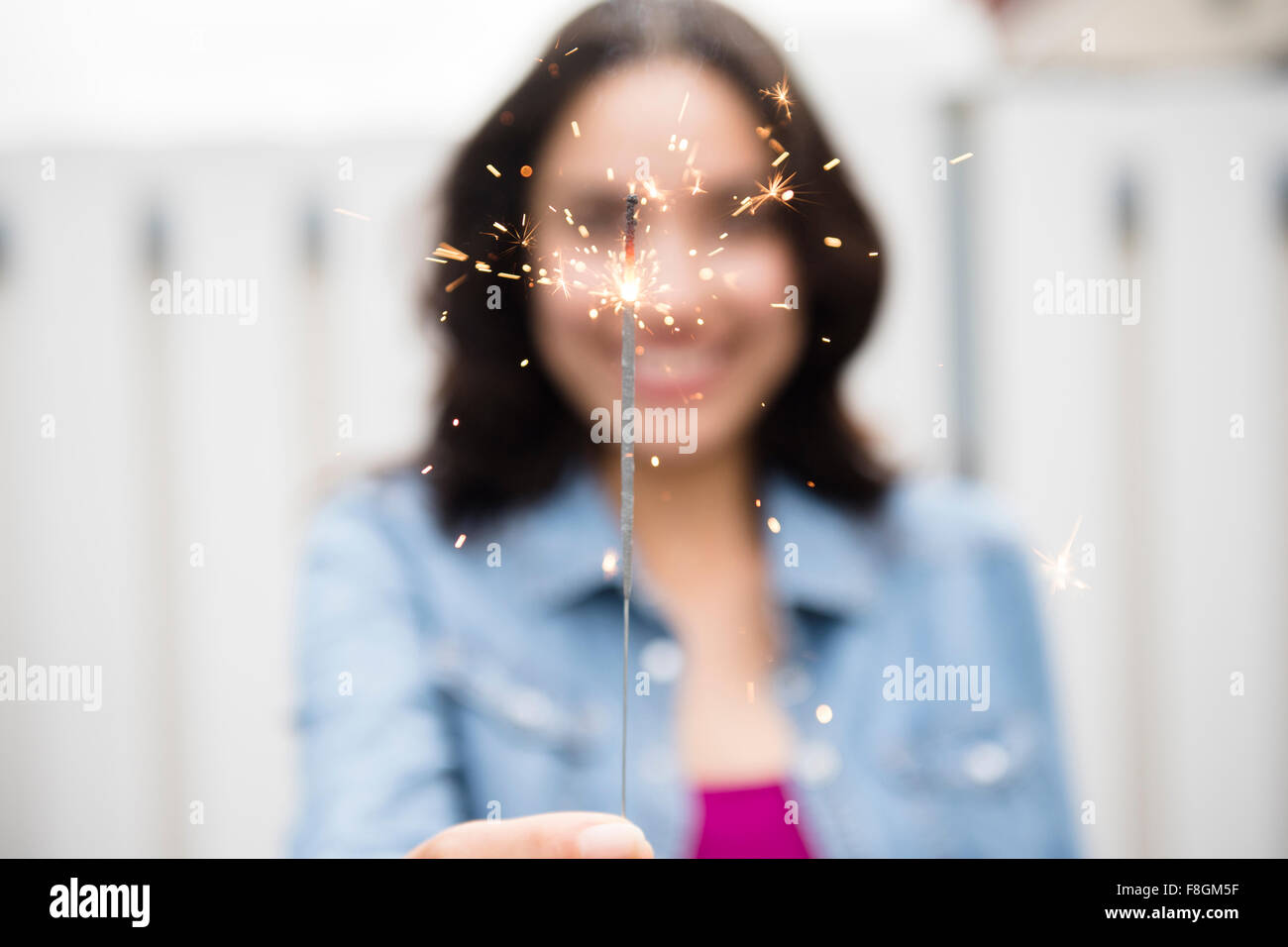 Hispanic woman holding sparkler Stock Photo