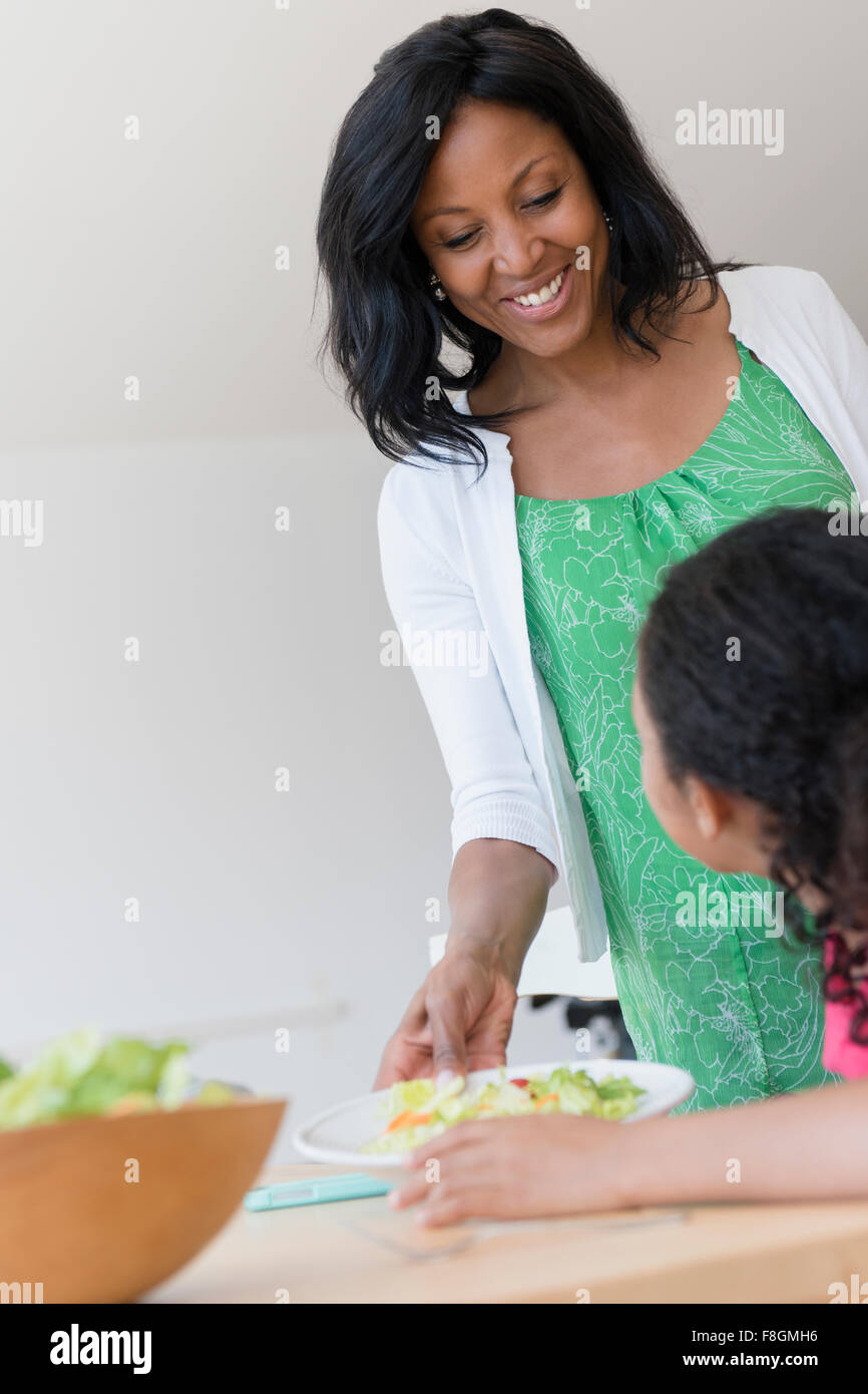 Mother serving daughter salad Stock Photo