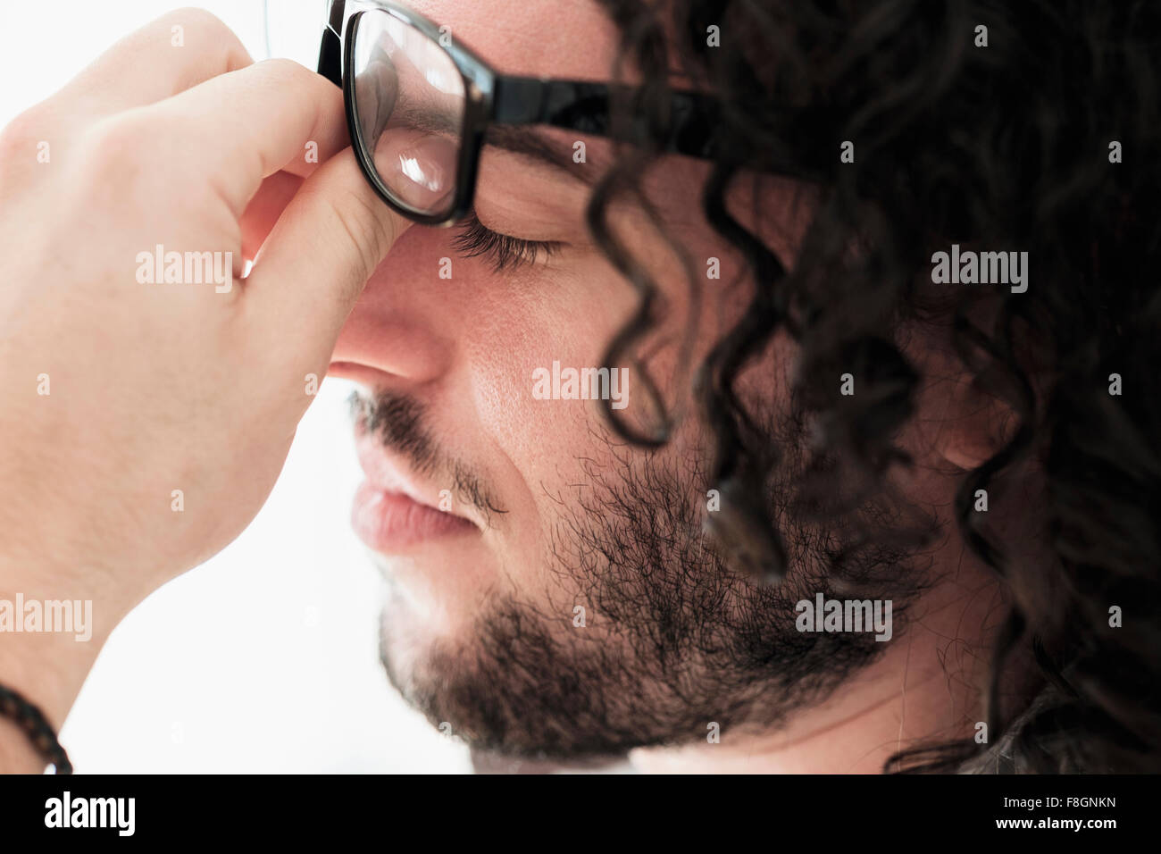 Stressed Caucasian man rubbing his eyes Stock Photo