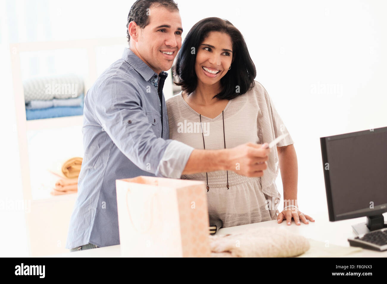 Hispanic couple paying at register Stock Photo