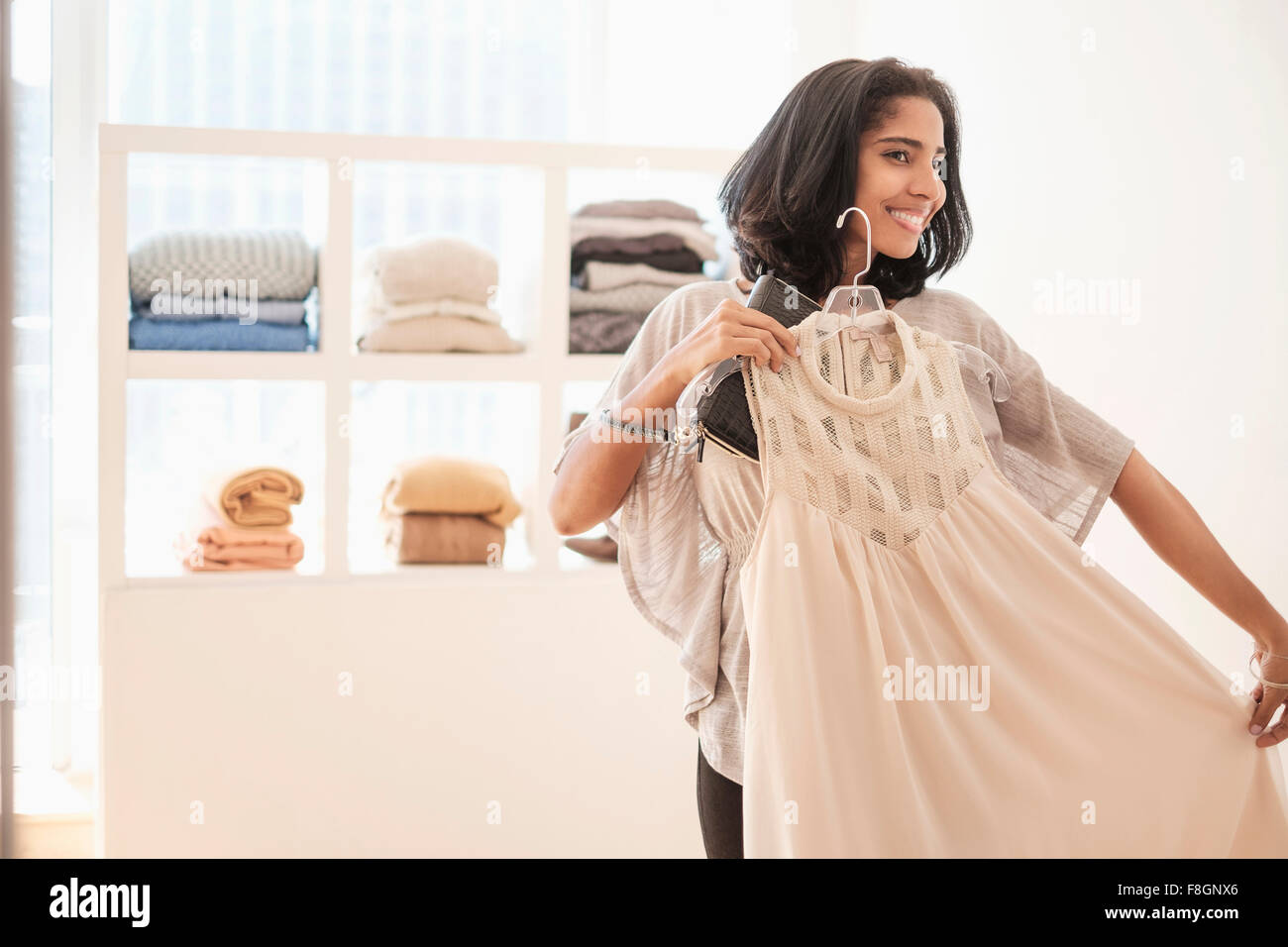 Hispanic woman admiring clothing in store Stock Photo