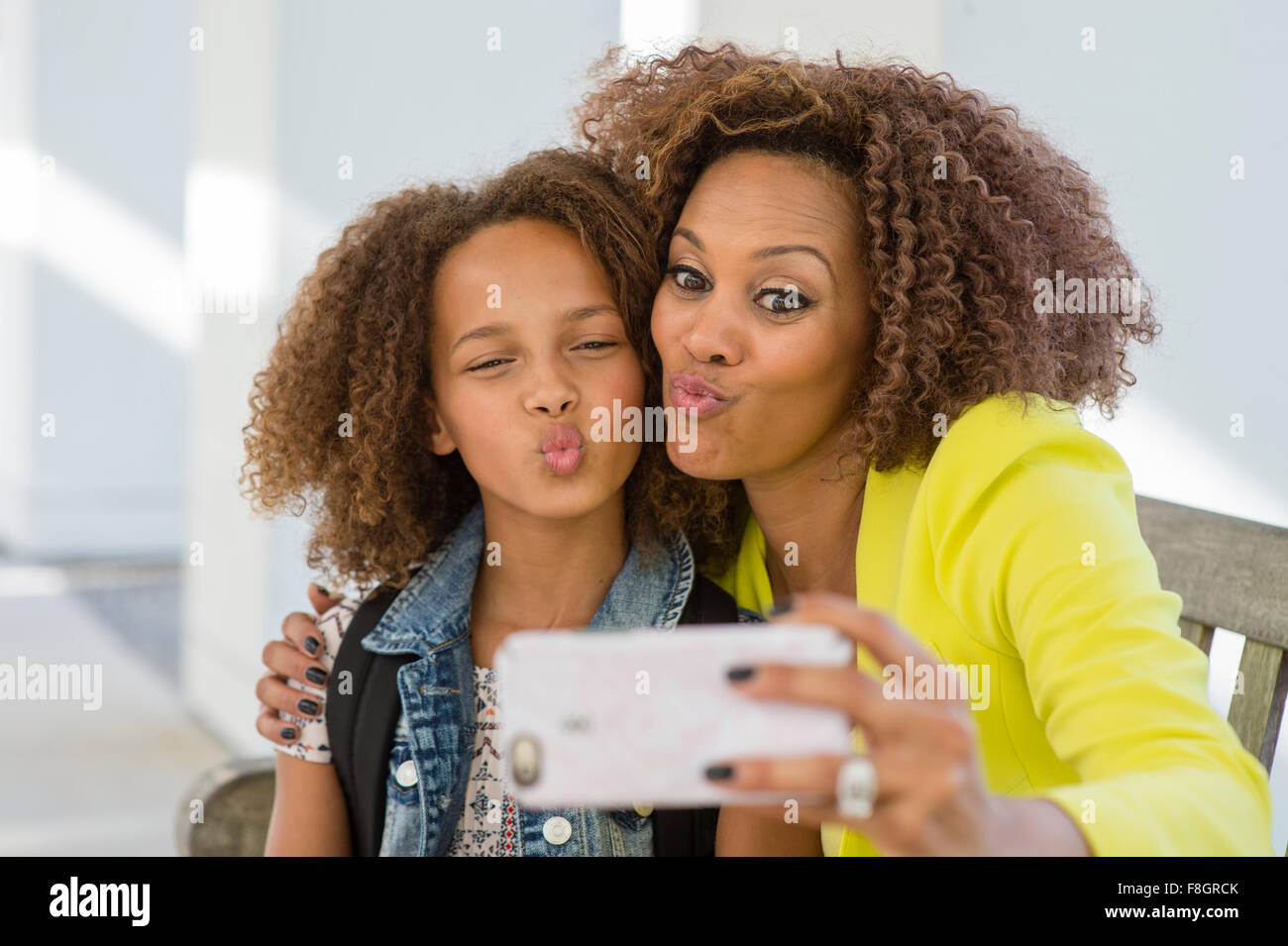 Mixed race mother and daughter taking selfie Stock Photo