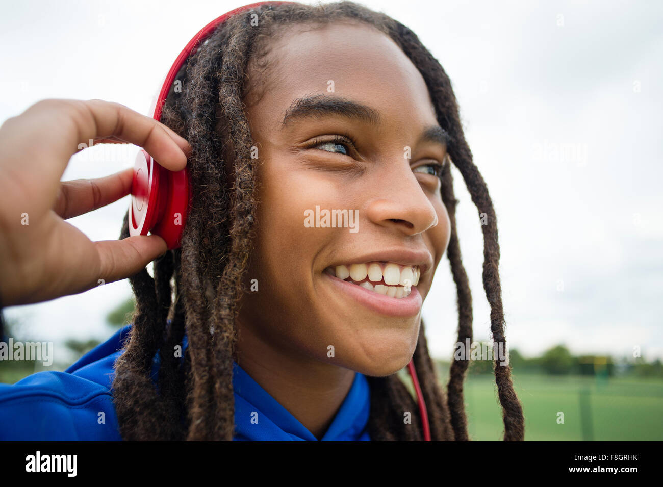 Mixed race boy listening to headphones outdoors Stock Photo