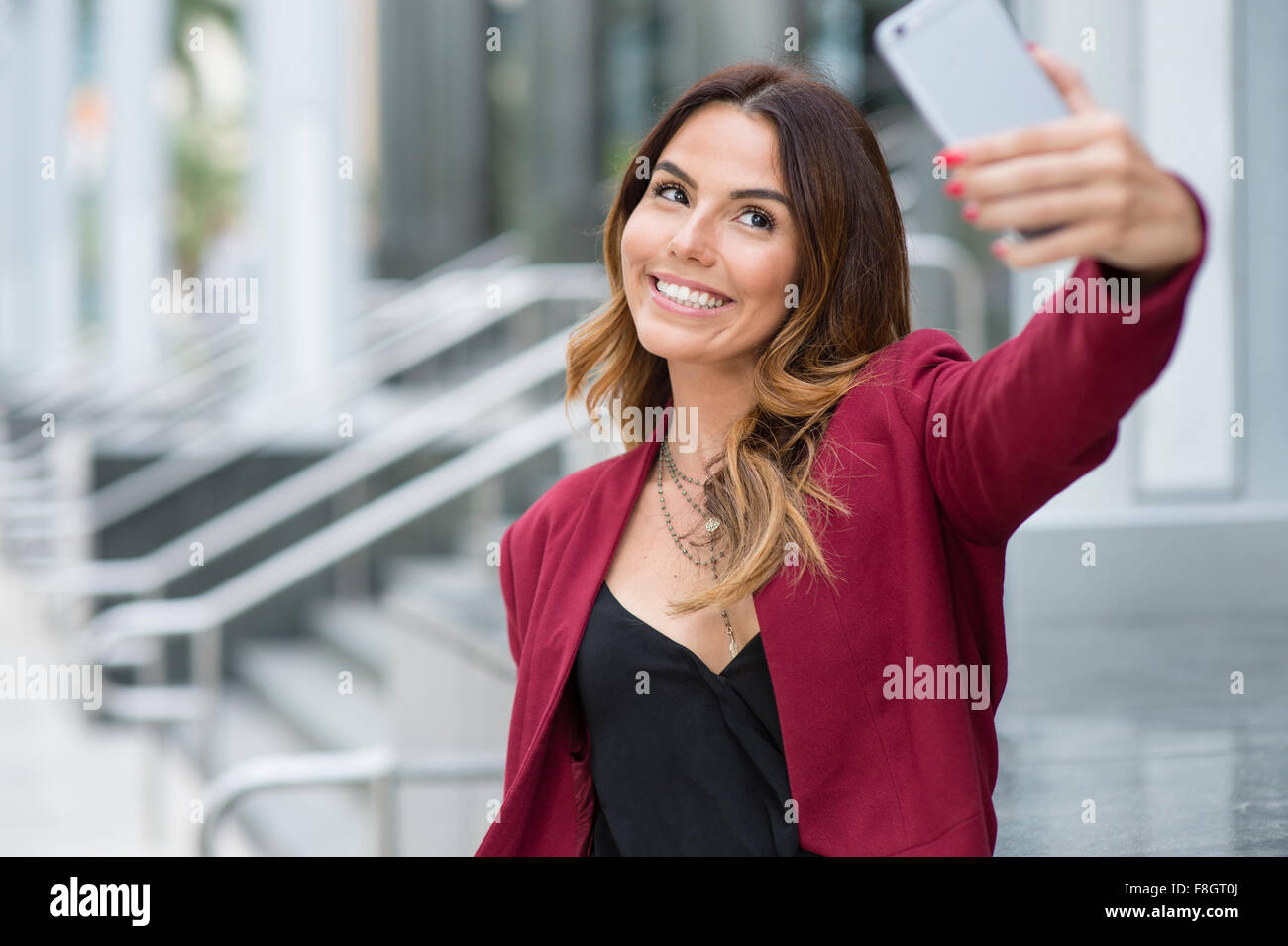 Hispanic businesswoman taking selfie outdoors Stock Photo