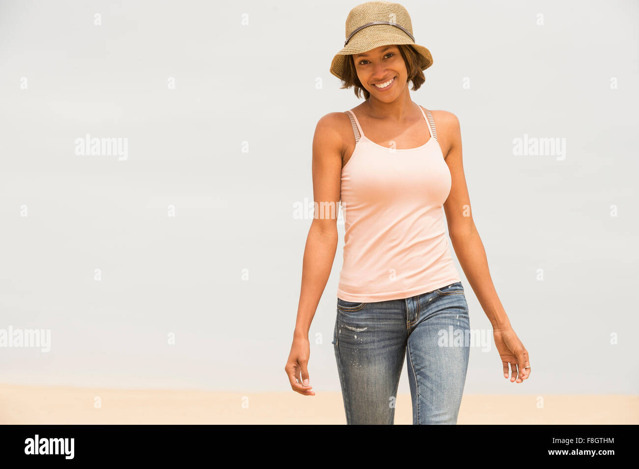 African American woman walking on beach Stock Photo