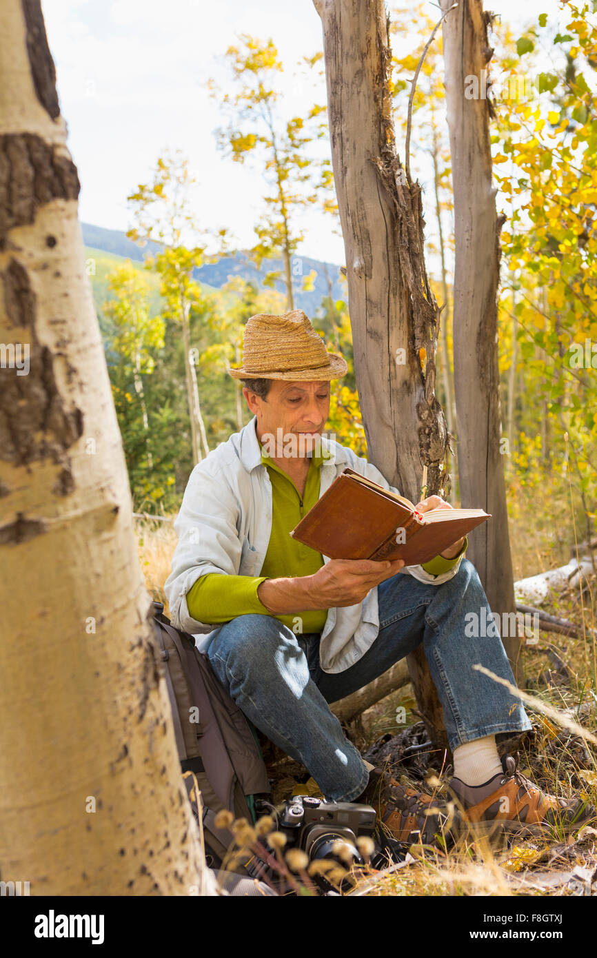 Man reading book in autumn forest Stock Photo