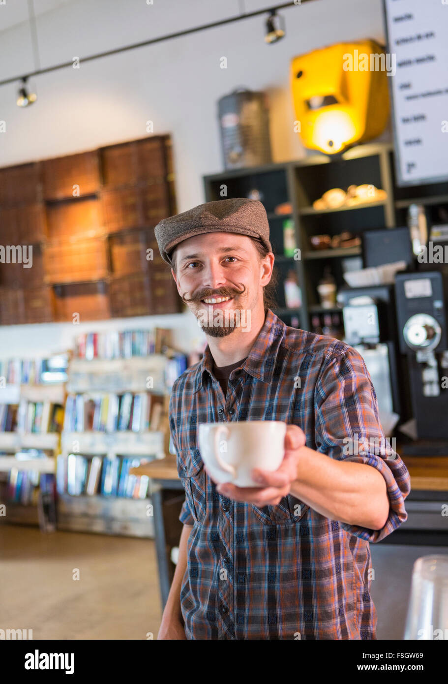 Caucasian barista serving coffee in cafe Stock Photo