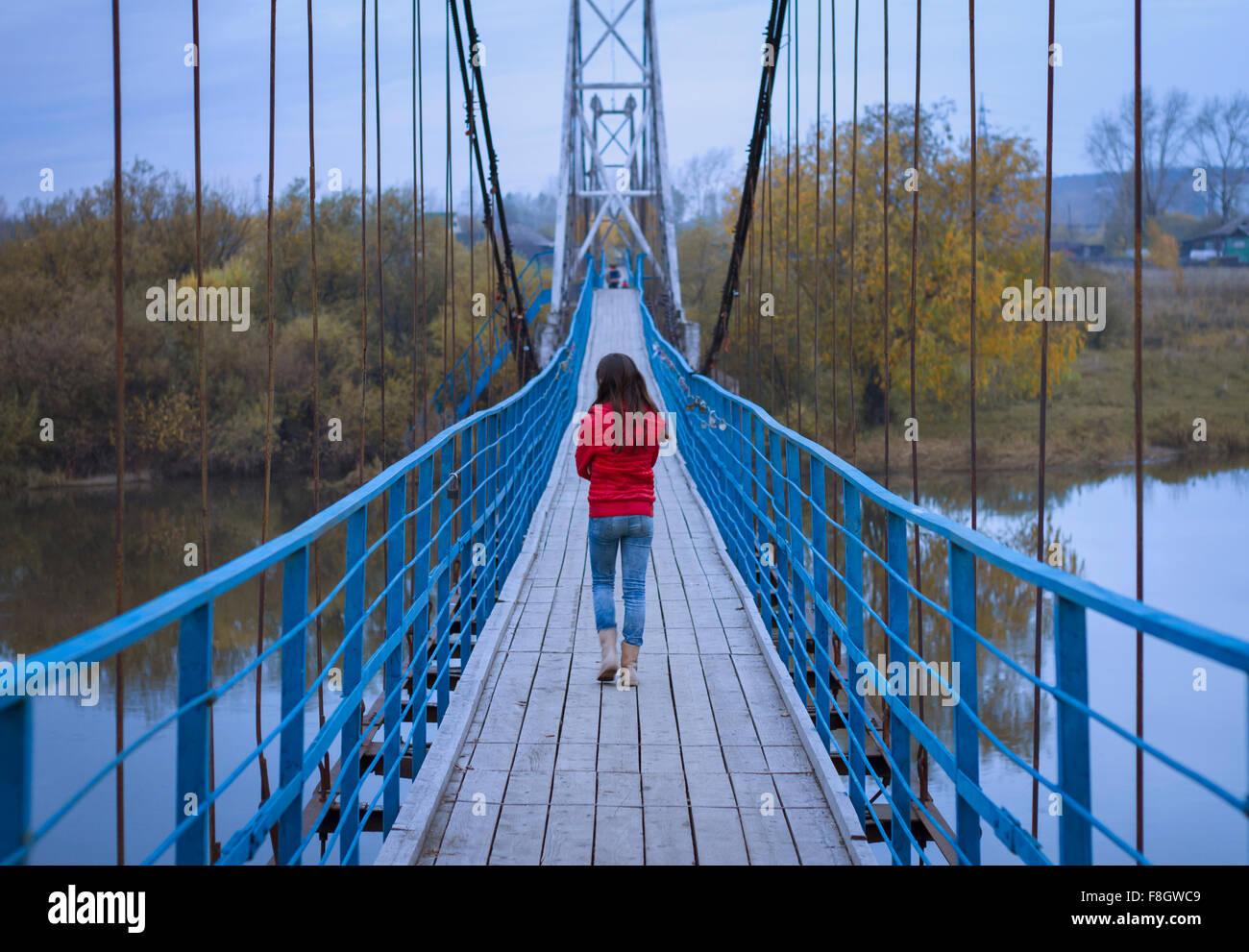 Caucasian girl walking on bridge Stock Photo