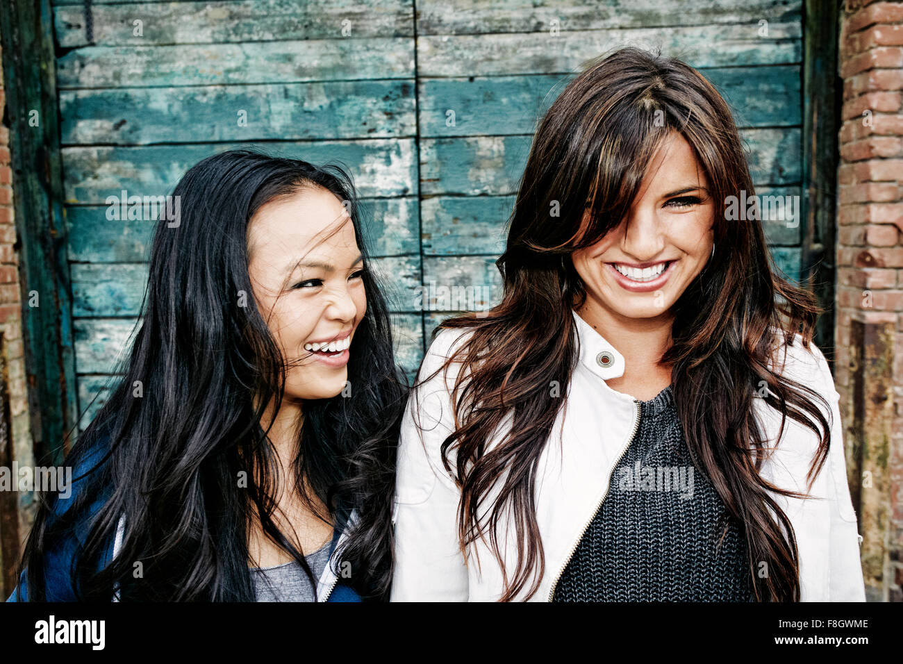 Women laughing at wooden wall Stock Photo
