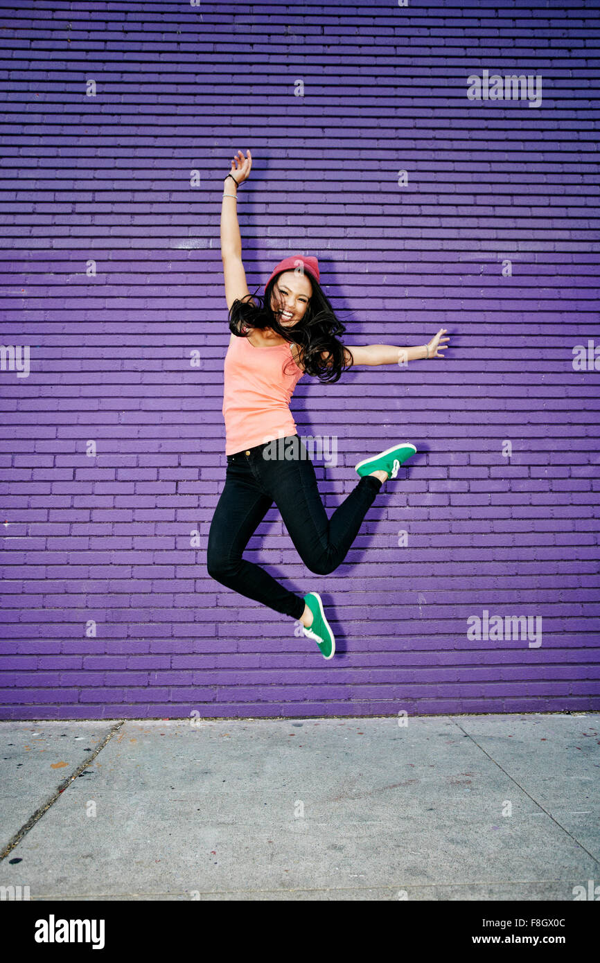Asian woman jumping for joy Stock Photo