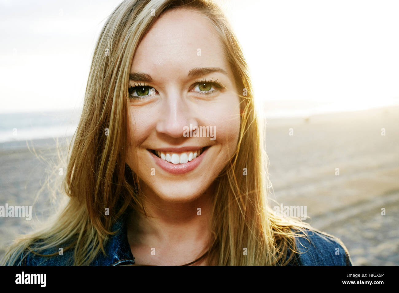 Caucasian woman smiling on beach Stock Photo