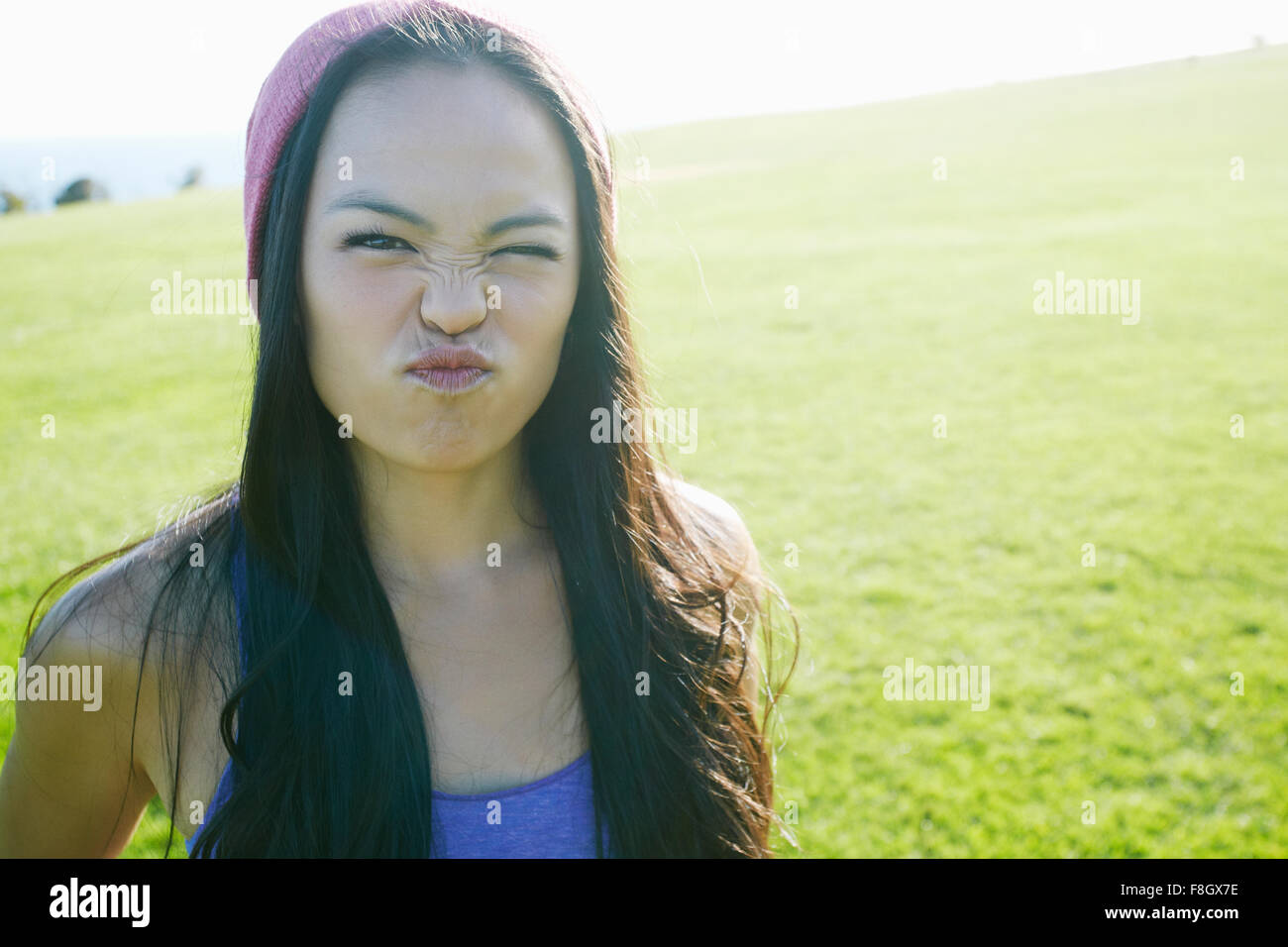 Asian woman making a face outdoors Stock Photo