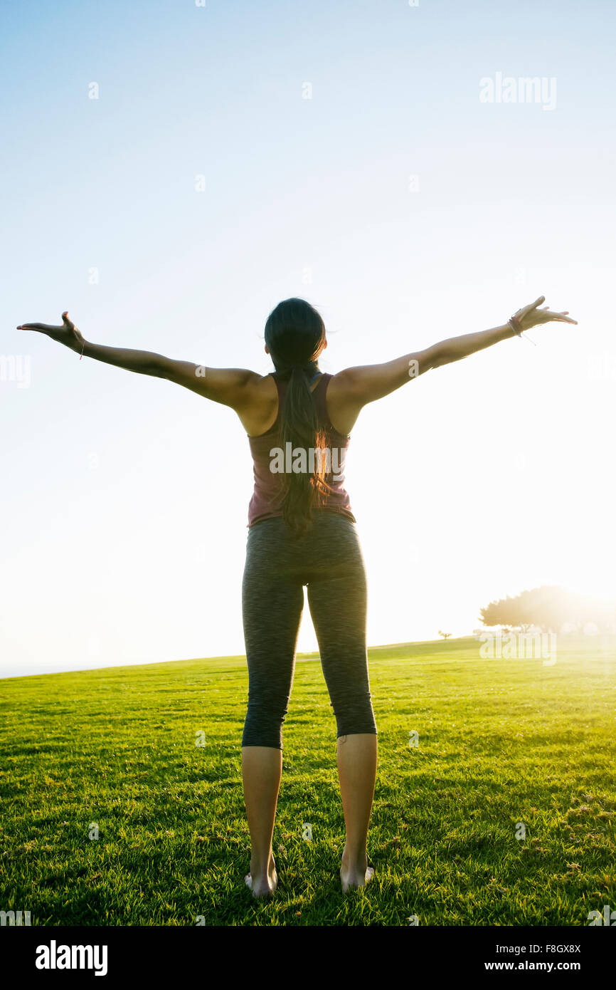 Asian woman standing with arms outstretched Stock Photo