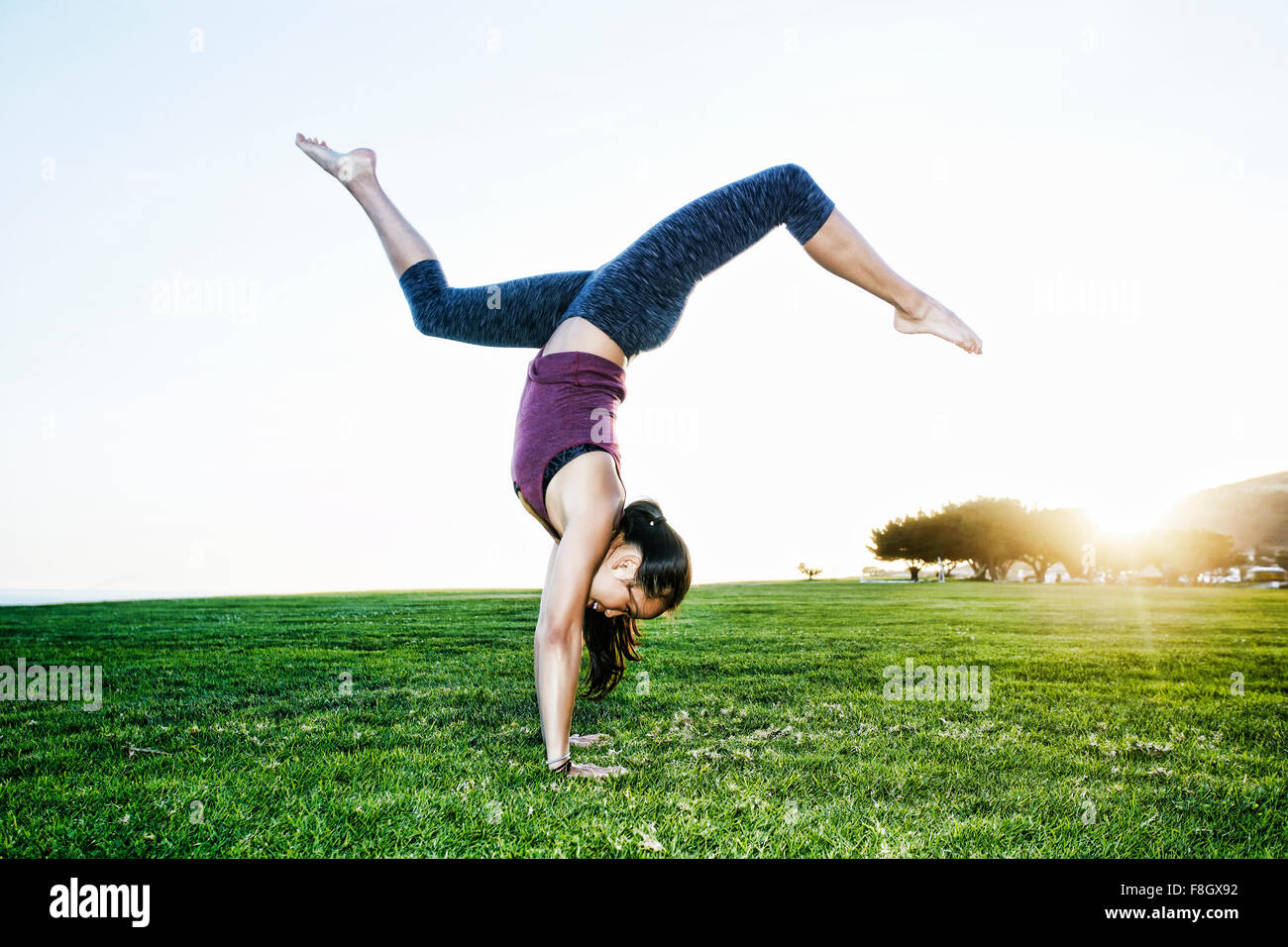 Asian woman practicing yoga outdoors Stock Photo