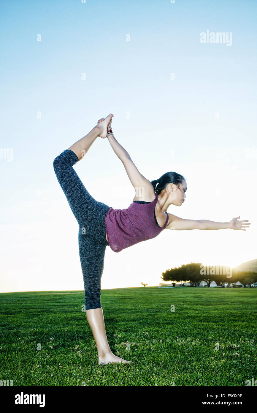 Asian woman practicing yoga outdoors Stock Photo