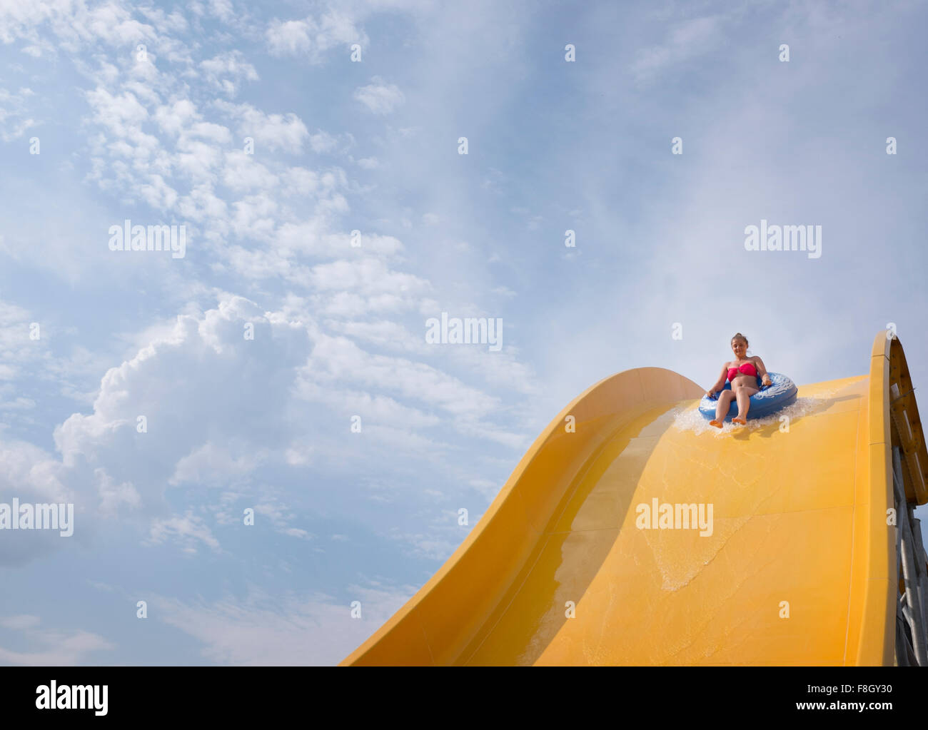 Hispanic woman on water slide Stock Photo