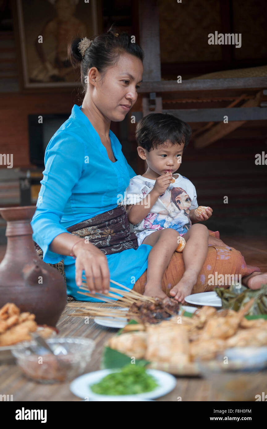 Asian mother and son eating on woven mat Stock Photo