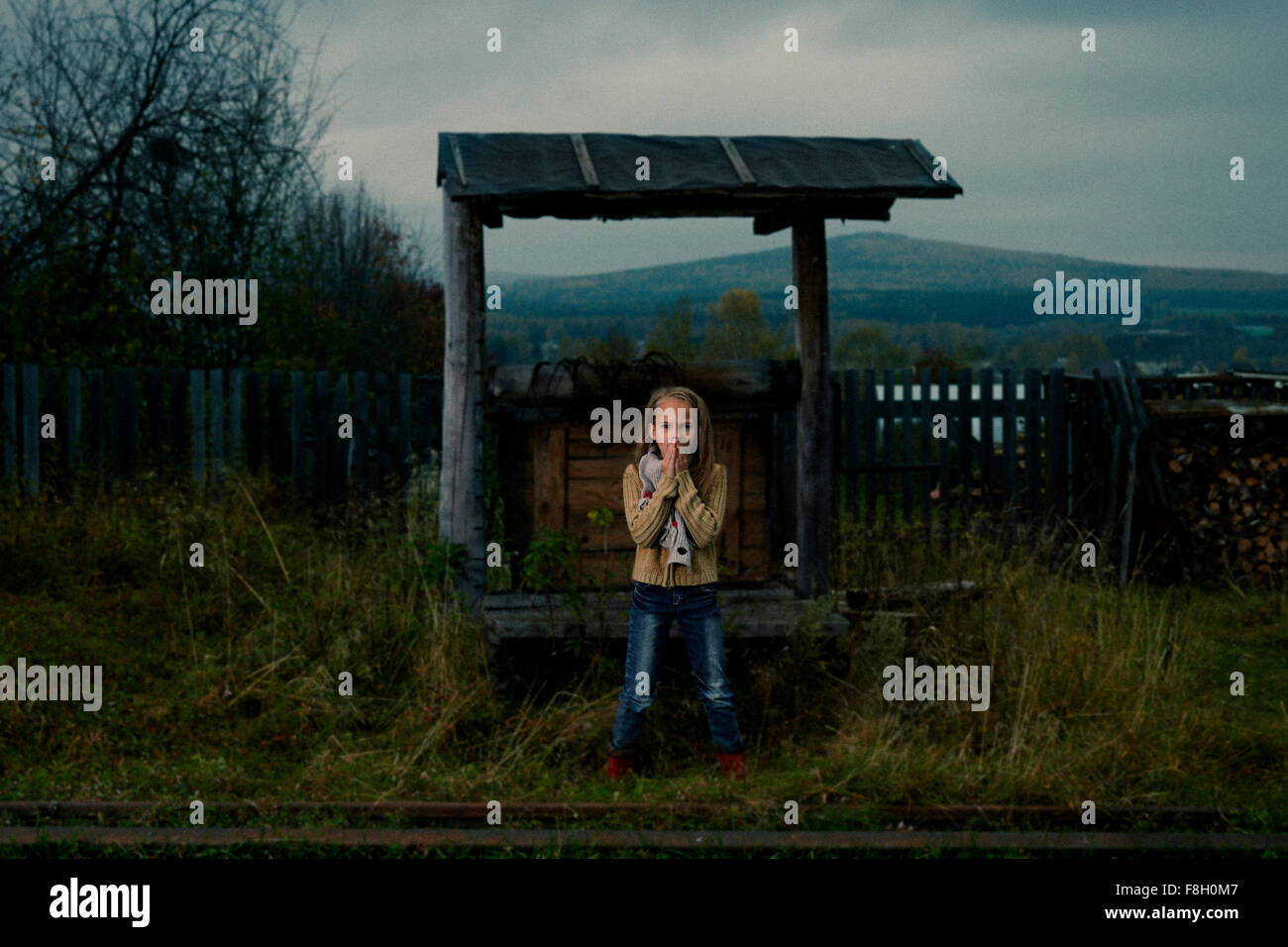 Caucasian girl waiting at rural train stop Stock Photo