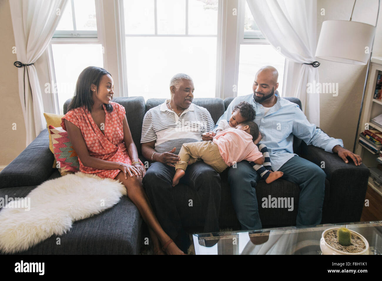 African American family relaxing on sofa Stock Photo