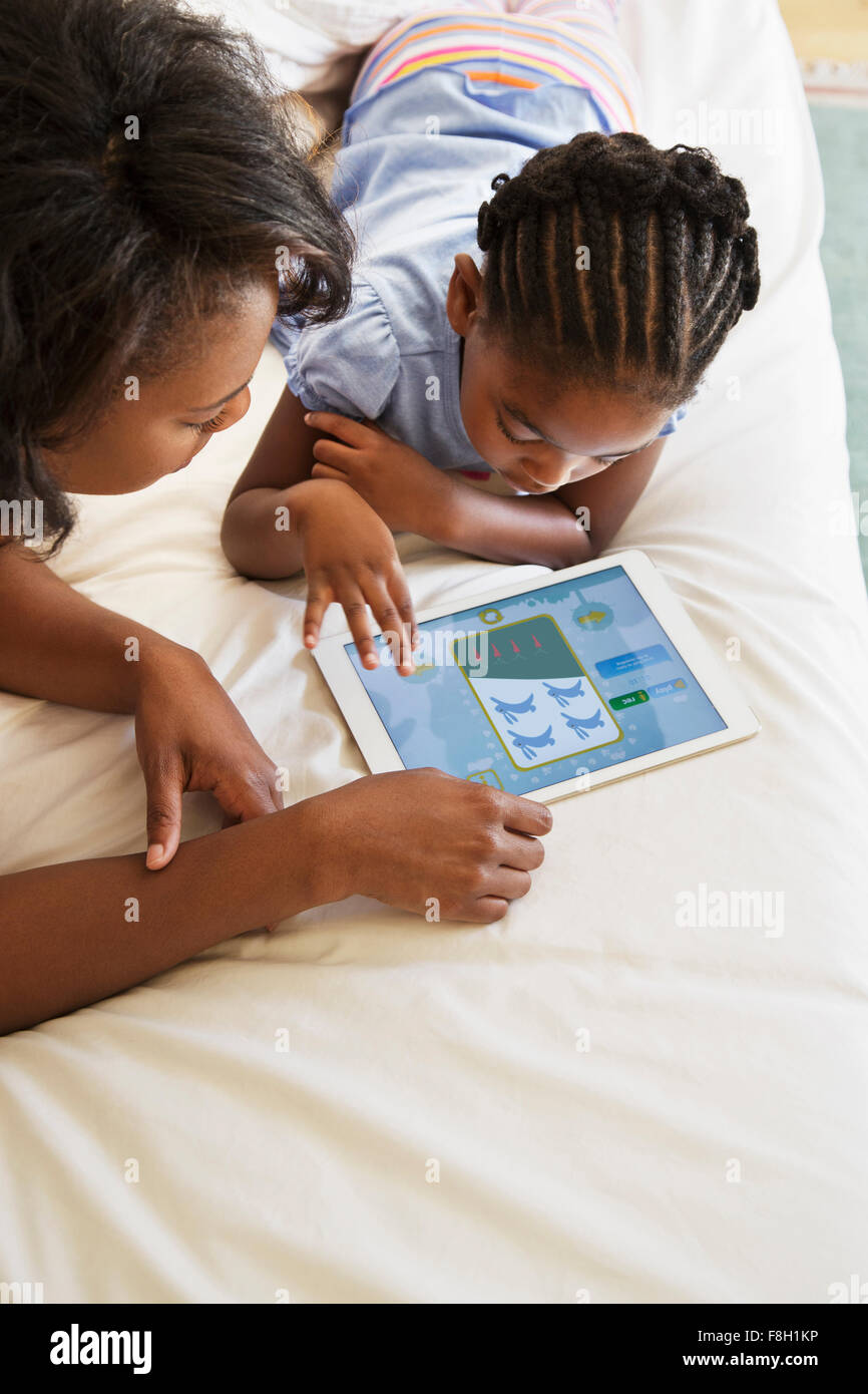 African American mother and daughter using digital tablet Stock Photo